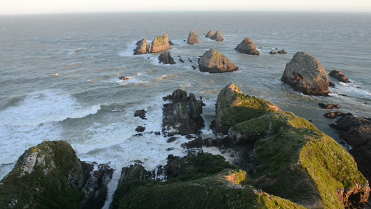 太阳落日照亮巨石和圆点的波浪视频