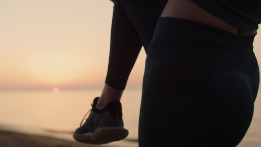 不知名的女孩在日落时单腿抱膝站立视频