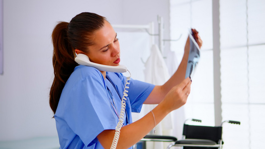 医疗护士在电话交谈时将病人的X光带入医院视频