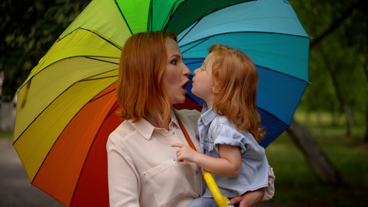 彩虹伞下的幸福母亲和孩子视频