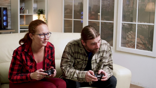 坐在沙发上玩电子游戏的情侣视频