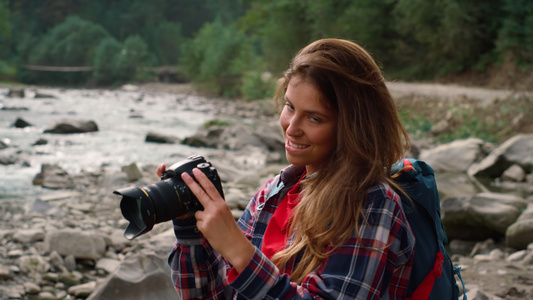 照片摄影师使用相机 有吸引力的女性在照相机上拍视频