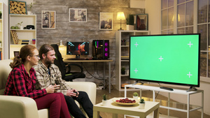 坐在沙发上玩电子游戏的情侣14秒视频
