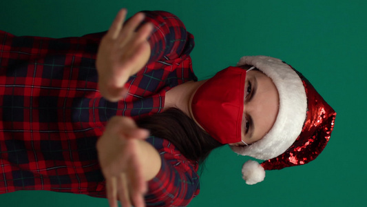 身戴圣诞帽和红色医疗面具的垂直视频女性用双手停止表态视频