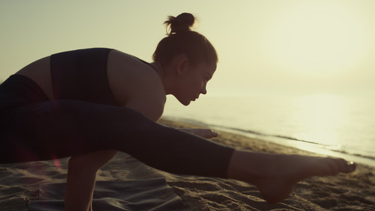 日落时在沙滩专业瑜伽女人视频