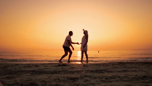 男人跪下向海滩上的女人求婚的浪漫剪影—情侣在日落时视频