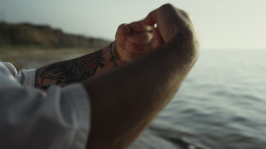 纹身的男人手在日落时分做热身视频