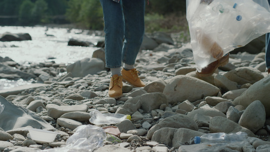 环保妇女和男人在河里捡瓶子视频