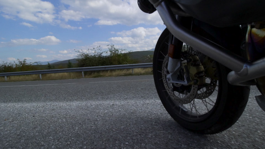骑着摩托车在一条自然道路上行驶在一辆颠簸的沥青路上视频