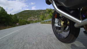 在自然的道路上骑摩托车关闭一个颠簸的沥青路的车轮加速11秒视频