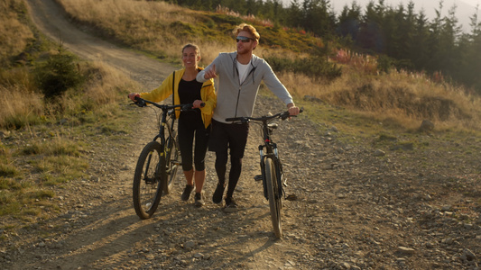 男人和女骑自行车在路上走视频