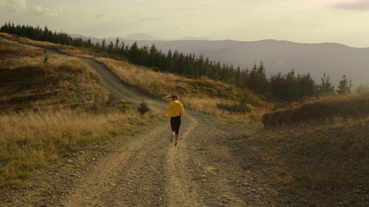 女性运动员在山区的公路上奔跑女运动员视频