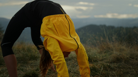 在山上伸展身体的运动女孩视频