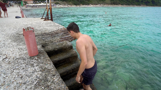 运动帅帅帅帅男孩从港口楼梯的海水里出来视频