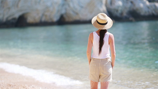 白沙滩热带海滩上的年轻美女帽子背景海滨的caucasian视频