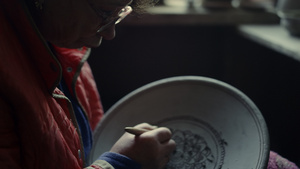 在陶器制品上做装饰品的老妇人13秒视频