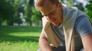 特写微笑英俊的男人坐在夏天公园蹲着抚摸动物12秒视频
