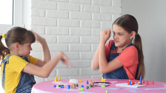 两个女孩玩桌游戏和一个朋友打电弧视频