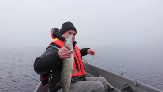 白人在芬兰湖的浓雾中夸耀着捕鱼的白种人视频