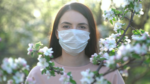 在春天的苹果花里戴着医疗面具的女人11秒视频