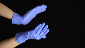 垂直视频带有蓝手套的医疗手在黑色背景上鼓掌11秒视频
