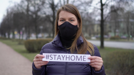 在一个城市里妇女面对着保护面罩留在家中流行的19视频