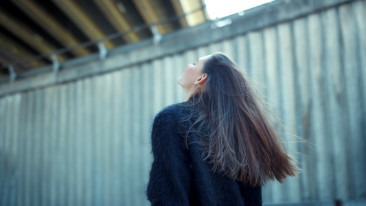 站在市街的年轻女人开心的挥舞着头发视频