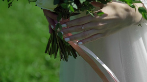 穿着结婚礼服的年轻新娘在公园里拿着花束6秒视频