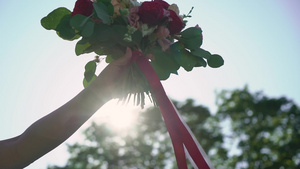 穿着结婚礼服的年轻新娘在公园里拿着花束花白色豪华礼服8秒视频