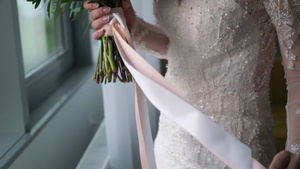 穿着结婚礼服的年轻新娘在室内盛放花束花白色豪华礼服9秒视频