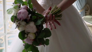 穿着结婚礼服的年轻新娘在室内盛放花束花白色豪华礼服6秒视频