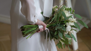 穿着结婚礼服的年轻新娘在室内盛放花束花白色豪华礼服7秒视频