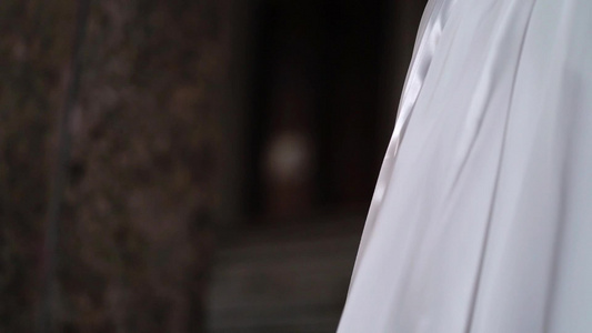 穿着结婚礼服的年轻新娘在城市里拿着花束花白色豪华礼服视频