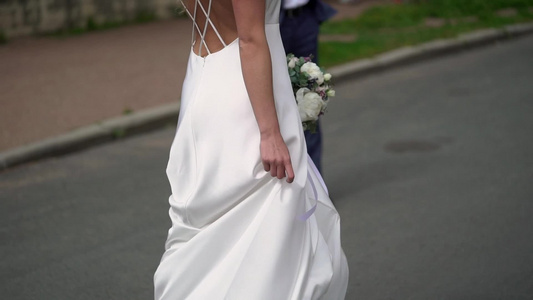 穿着婚纱的年轻新娘在城市里盘旋白色豪华礼服时装视频