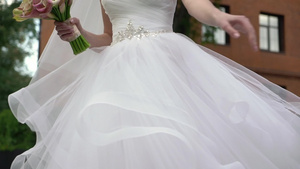 穿着婚纱的年轻新娘在城市里盘旋白色豪华礼服时装7秒视频