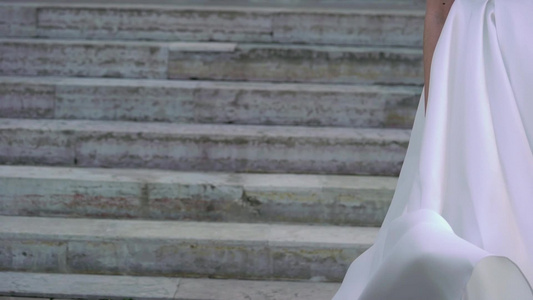 穿着婚纱的年轻新娘在城市中挥舞和扔尾巴白色豪华礼服视频