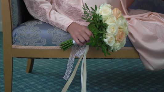 穿着内衣或浴袍的年轻美女鲜花新娘花束婚礼早上女人摆姿势视频