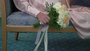 穿着内衣或浴袍的年轻美女鲜花新娘花束婚礼早上女人摆姿势9秒视频