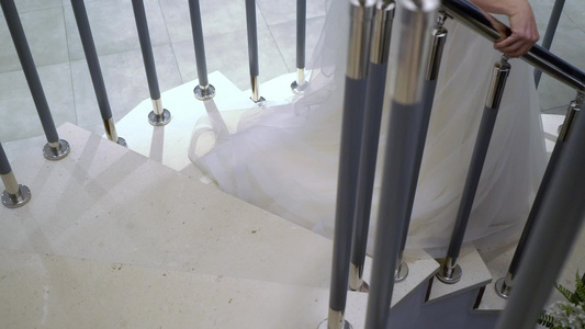 穿白色婚纱的年轻新娘从楼梯上下来视频