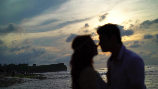 日落时在海中相爱的情侣视频