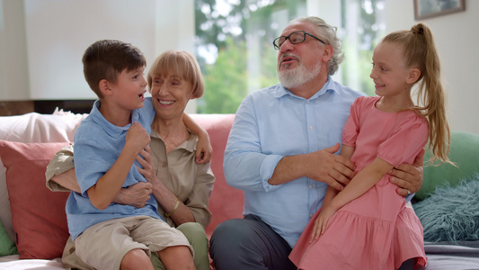 快乐的爷爷奶奶在家和孙子孙女聊天视频