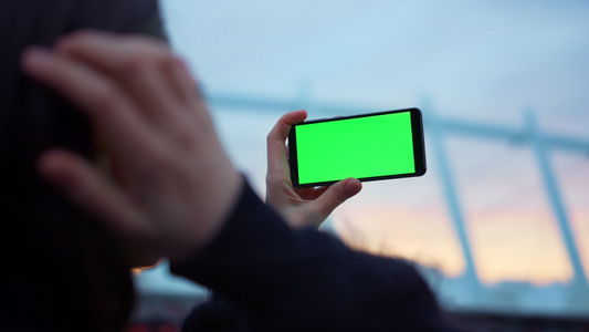 【无需肖像权】女孩用智能手机上的绿色屏幕拍摄照片视频