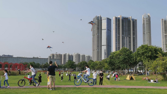 城市家庭周末在广场上放风筝视频