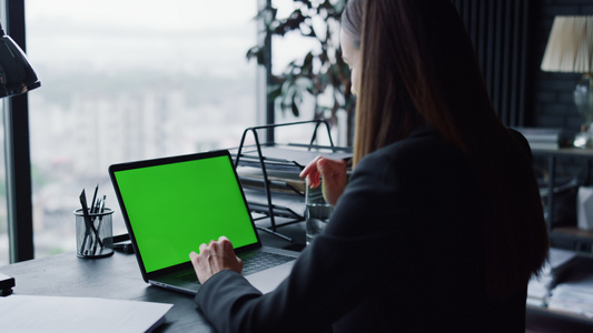 有自信的女商人在办公室用绿色屏幕在笔记本电脑上进行视频通话视频
