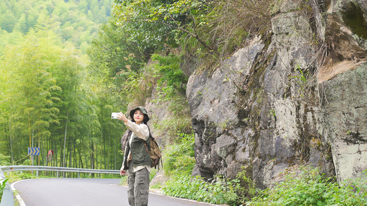 女青年登山远足用手机拍照视频