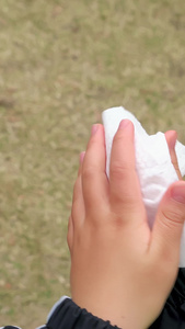秋冬季节户外小男孩使用纸巾擦拭手部第一视角视频