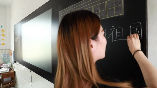 实拍美女老师在黑板板书的背影视频