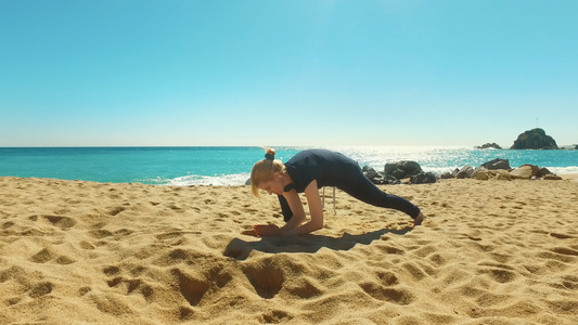在阳光明媚的沙滩上做瑜伽锻炼视频