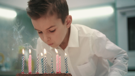 男孩在生日蛋糕上吹蜡烛视频