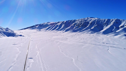 大雪中的天山山脉和山脚下公路视频